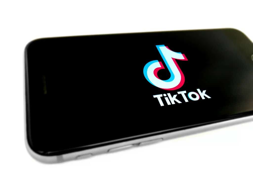 The logo of tiktok is displayed on a phone.