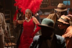 ‘The Color Purple’ (2023) 4K UHD Blu-Ray Review – A Creatively Frustrating Musical Adaptation A woman in a red feathered dress is dancing with other people.
