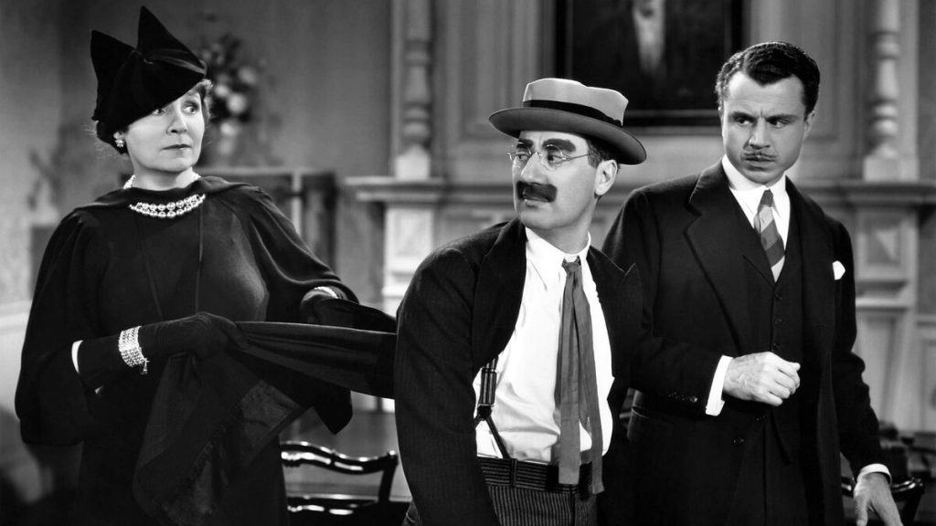 Three people in suits and hats standing next to each other.