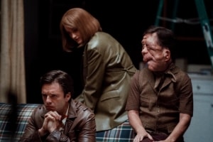 A24 To Release The Sebastian Stan Dark Comedy ‘A Different Man’ On Blu-Ray This June Three people seated in a room with one person in the foreground appearing thoughtful and the others engaged in a conversation in the background.