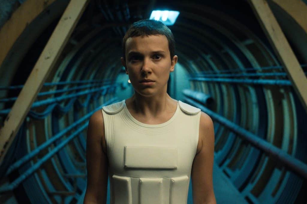 A woman in a white outfit standing in a tunnel.