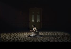 Magnet Releasing Debuts Clip For Supernatural Thriller ‘Amelia’s Children’ (EXCLUSIVE) A woman sitting on a circular floor in a dark room.