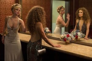 Two women looking at themselves in a mirror.