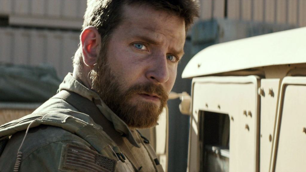 A bearded man in military attire looking intently to the side.