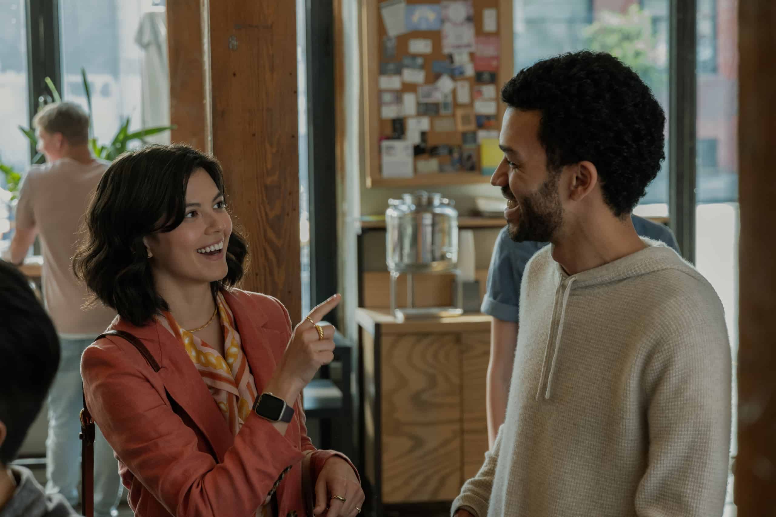 A man and woman talking in a coffee shop.
