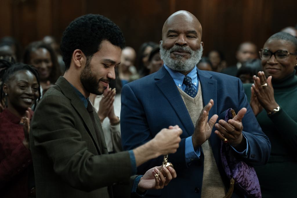 A man in a suit and tie clapping with a man in a suit and tie.