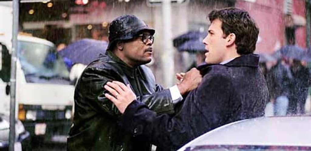 Two men engaging in a confrontational conversation in the rain, with one man gripping the other's coat.