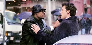 Two men engaging in a confrontational conversation in the rain, with one man gripping the other's coat.