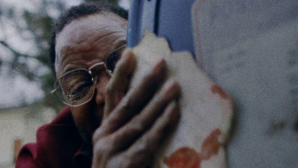 Man wipes glasses with cloth, close-up view.