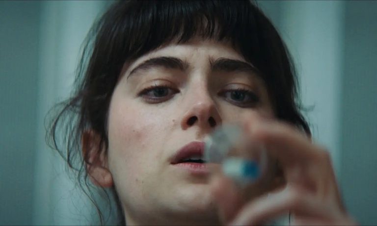 A woman is holding a bottle of liquid in her hand.