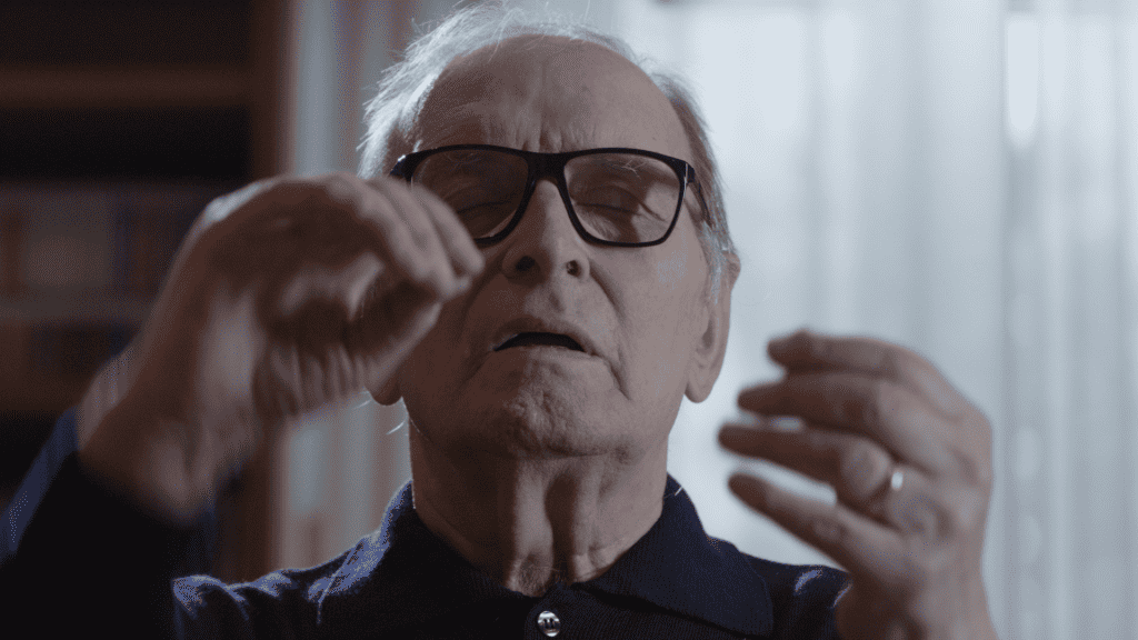 A man in glasses is holding his finger up.