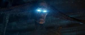 A cgi image of mothra, a giant mythic moth creature, with glowing eyes, winged and poised for action in a night setting.