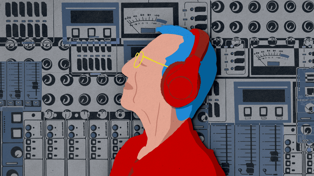 Person in red with headphones against a backdrop of audio equipment.