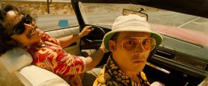 Two individuals enjoying a ride in a vintage convertible car on a sunny day.