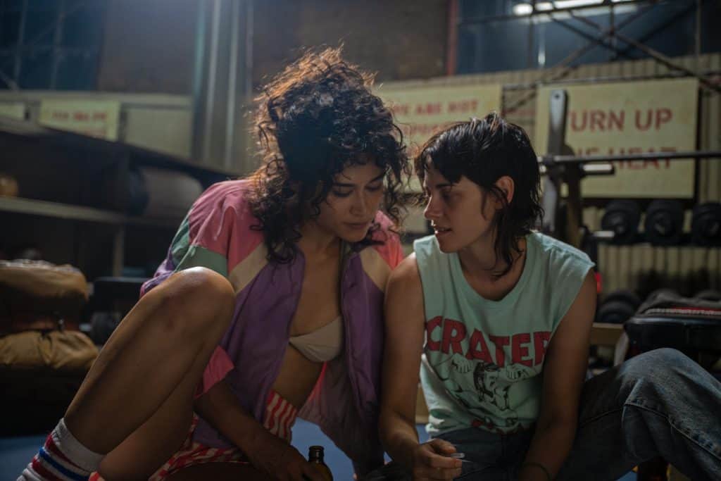 Two women sitting on the floor in a gym.