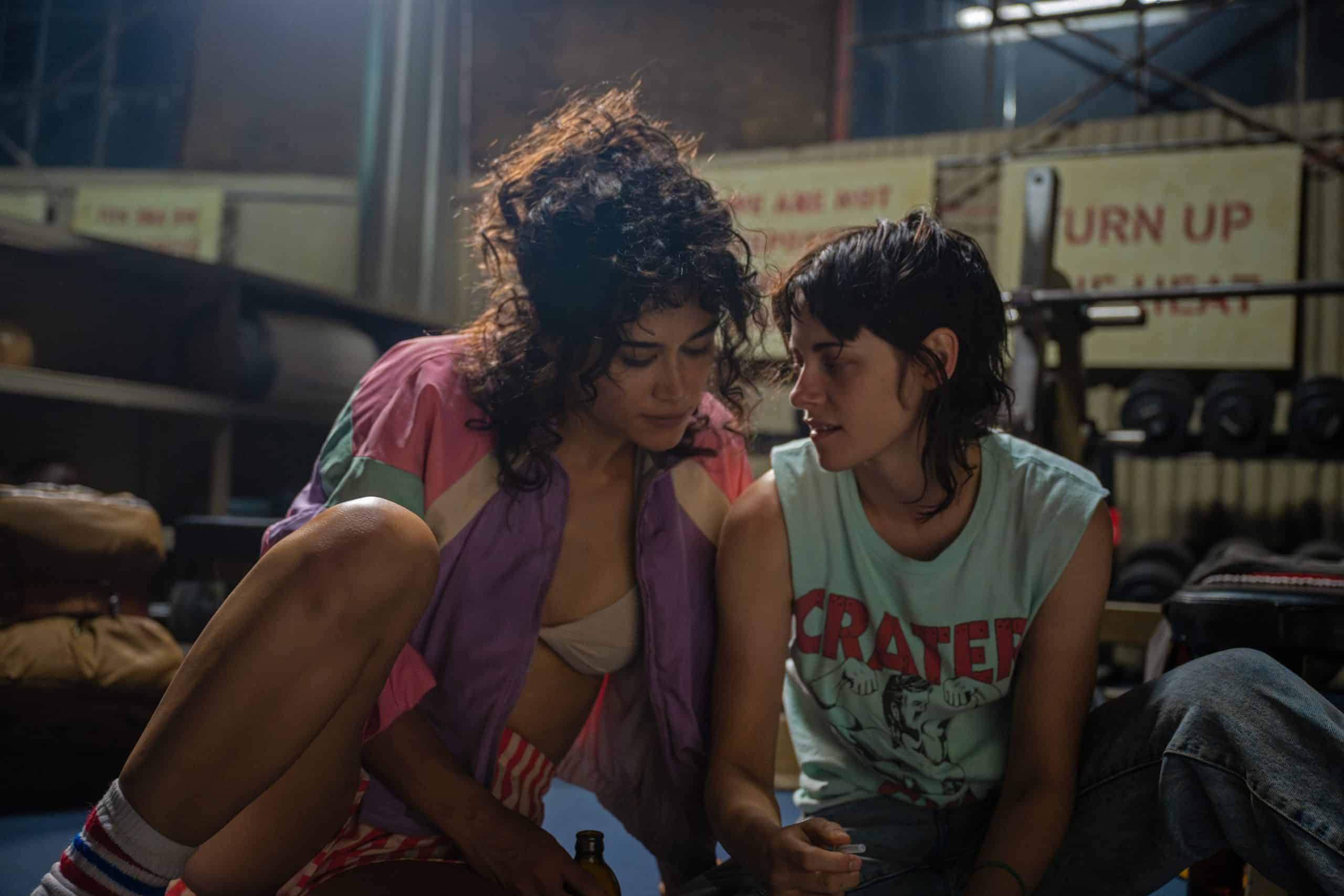 Two women sitting on the floor in a gym.