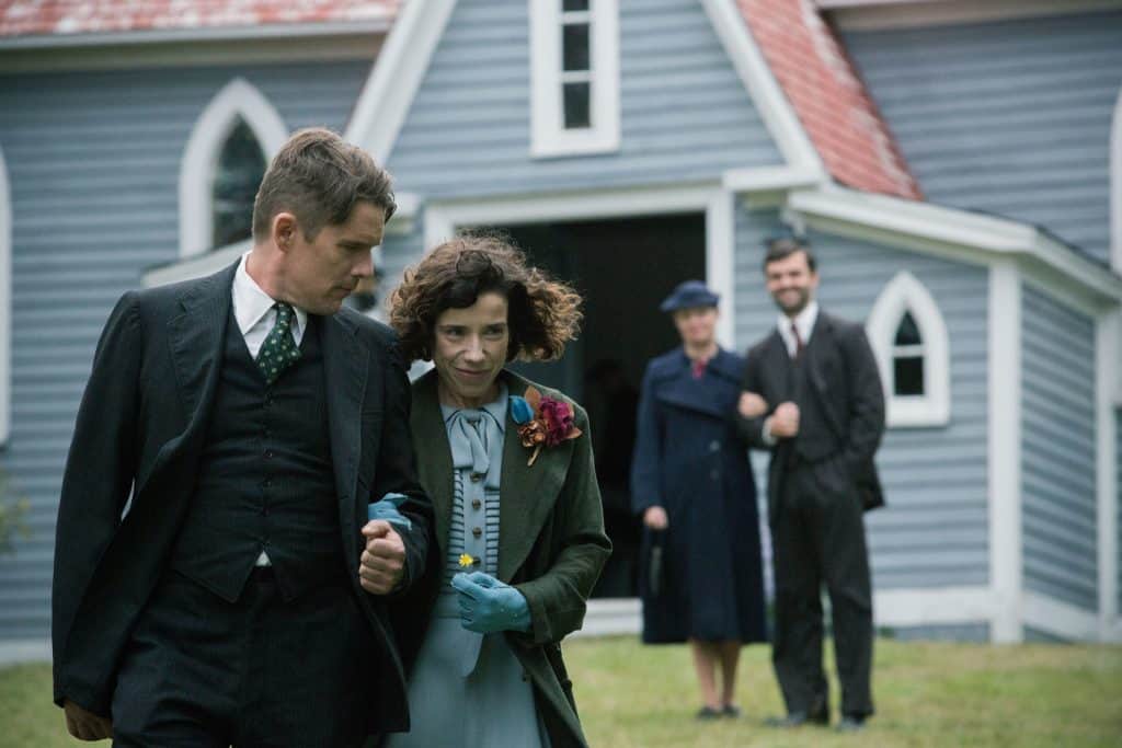 A man and woman walking in front of a church.