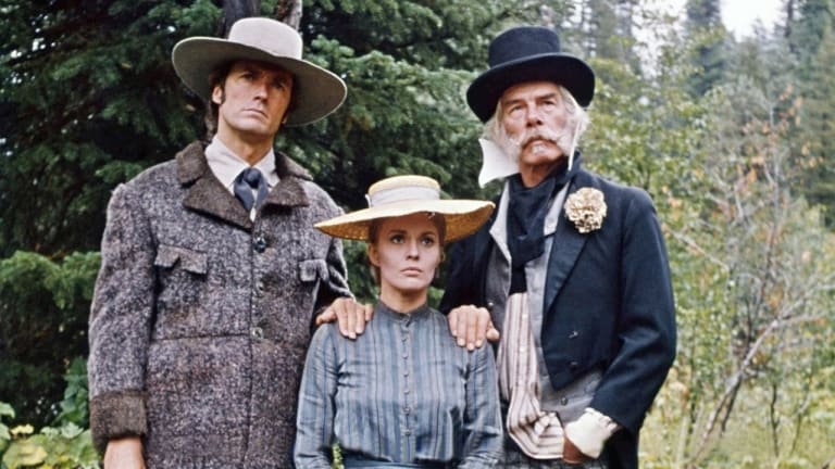 Three actors dressed in period costumes standing outdoors, portraying characters from a historical drama.