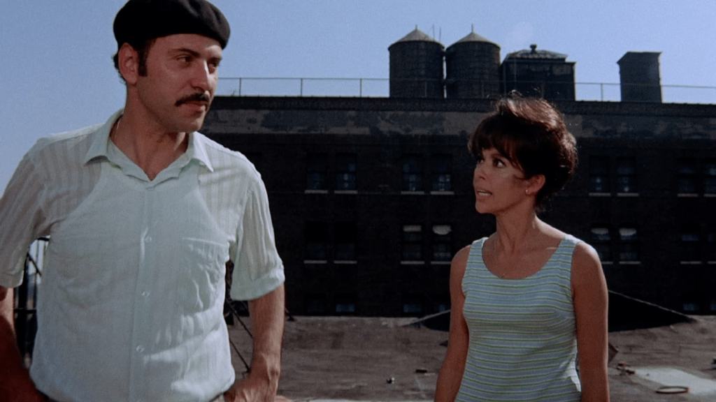 A man and woman standing on top of a building.