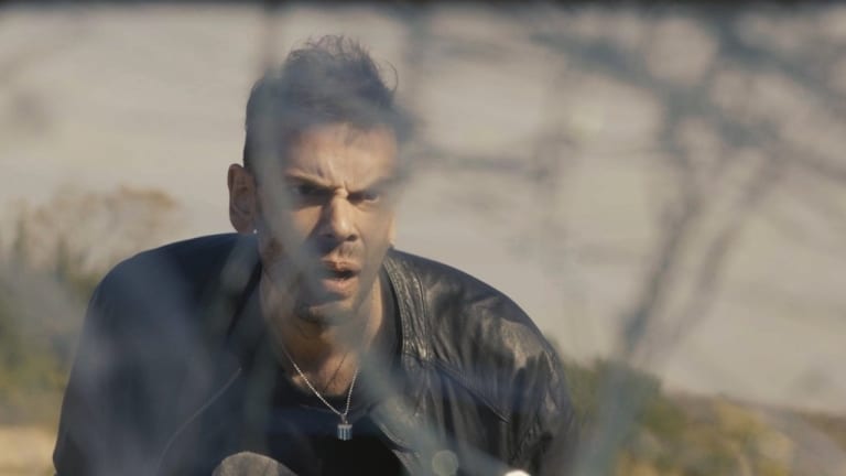 ‘Punto Rojo’ Blu-Ray Review – A Very Entertaining, Down And Dirty Crime Film A man with an intense expression seen through a blurred foreground.