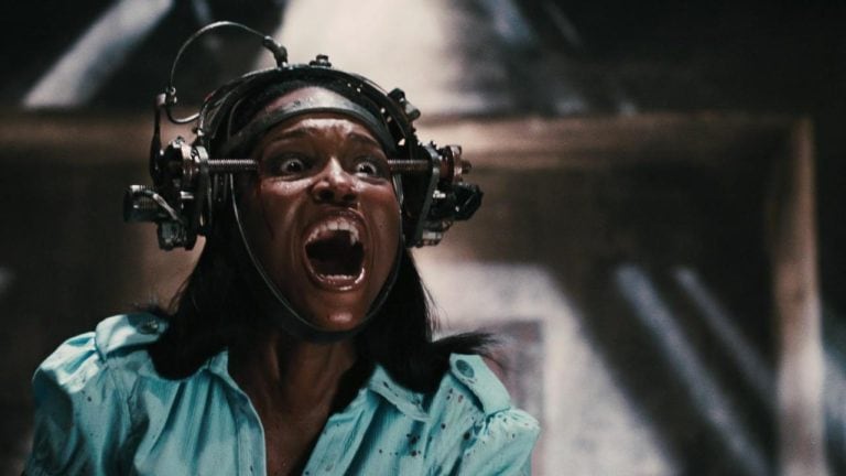 Lionsgate To Give A Trio Of ‘Saw’ Sequels Their 4K UHD Blu-Ray Debut This November A woman with a machine on her head.