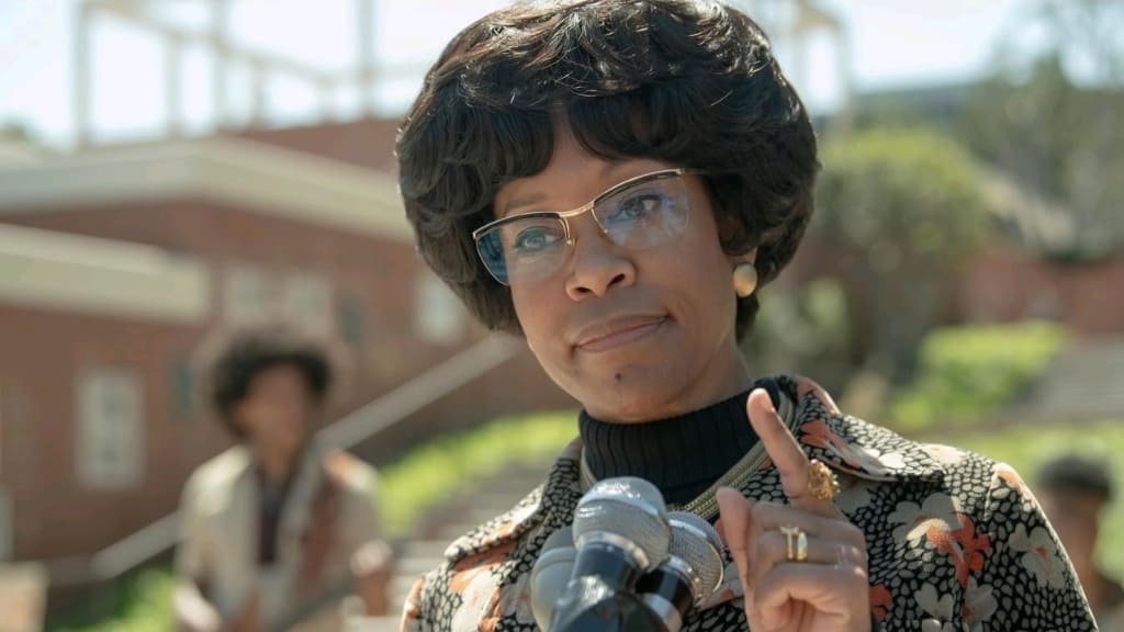 Woman in vintage attire speaking at a microphone outdoors.