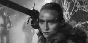 A black and white photo of a woman holding a sword.