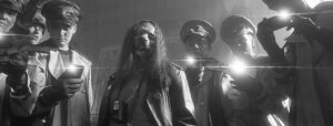 A black and white photo of a group of people holding flashlights.