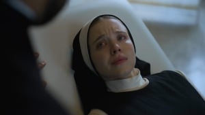 A nun appearing distressed or in a moment of sorrow.