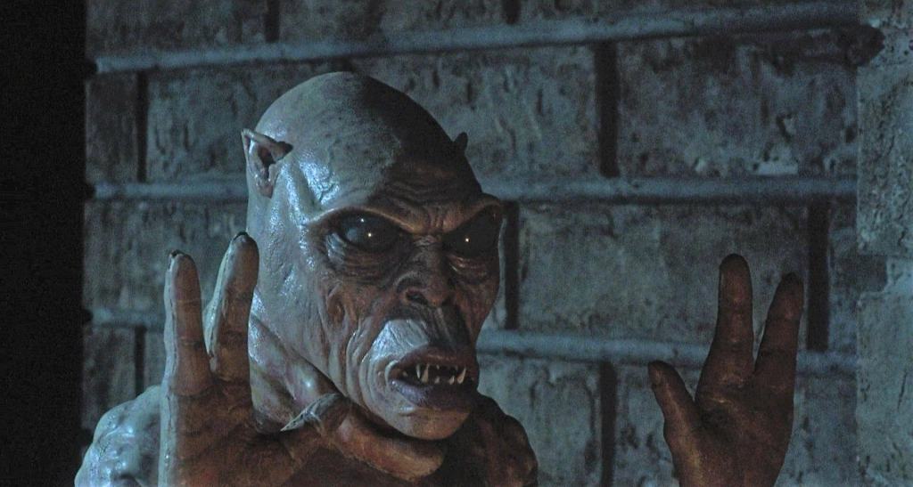 A close-up of a creature with monstrous features peeking around a corner.