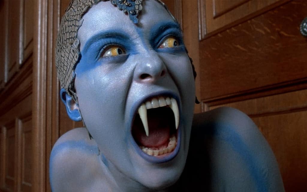 An individual with blue skin and unique head adornments is expressing intense emotion.