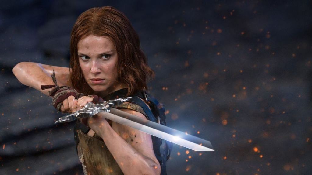 A determined woman wielding a sword with sparks flying in the background.