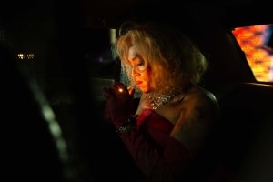 ‘DogMan’ Blu-Ray Review – Caleb Landry Jones Makes The Most Of This Unusual Tale A woman in an evening gown lighting a cigarette in the backseat of a car at night.