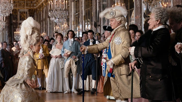 ‘Jeanne Du Barry’ Review – An Exquisite-Looking Movie Full Of Authenticity, Sensitivity And Unevenness A man in an 18th-century military uniform bows to a woman in an elaborate gown in a grand, mirrored ballroom surrounded by elegantly dressed attendees.