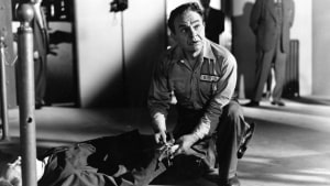 Film Noir: The Dark Side Of Cinema XVII Blu-Ray Review – Edward G. Robinson Commands Three Engrossing Tales A black-and-white still of a man in a prison uniform kneeling next to another person lying on the floor.