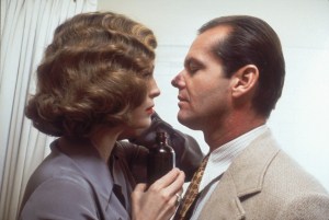 An intimate moment between a man and a woman, both dressed in vintage clothing, suggesting a still from an older film or a scene set in the past.