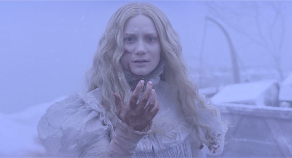 A woman with long blonde hair, wearing a white dress, looks alarmed as she reaches out her hand, with a snowy backdrop.