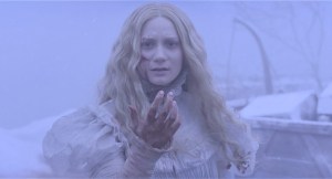 ‘Crimson Peak’ Arrow Video 4K UHD Blu-Ray Review – Guillermo del Toro’s Gothic Gem A woman with long blonde hair, wearing a white dress, looks alarmed as she reaches out her hand, with a snowy backdrop.