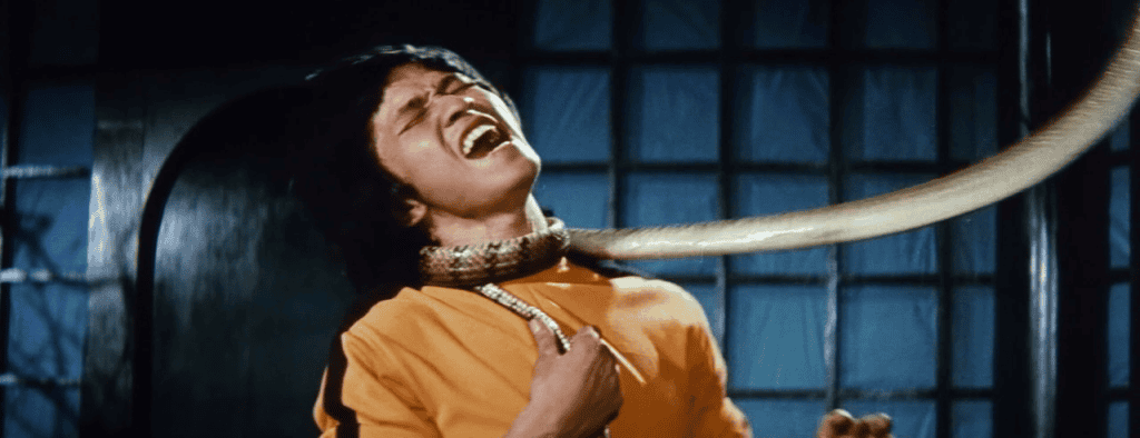 A person appears distressed while being constricted by a large snake.