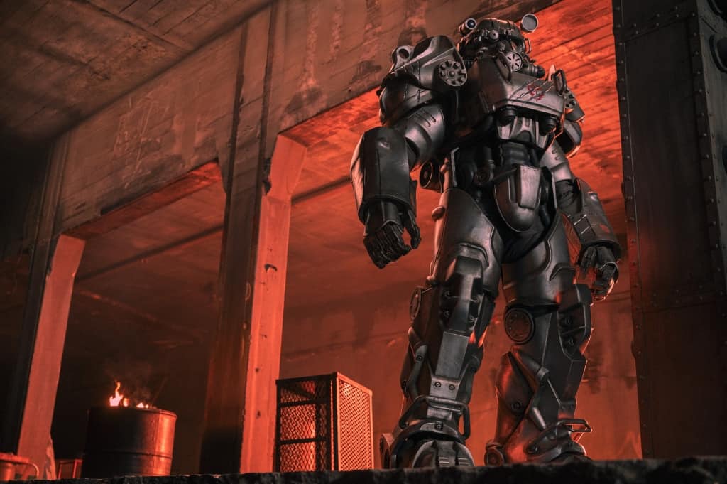 A humanoid robot in an industrial setting, illuminated by ambient red lighting.