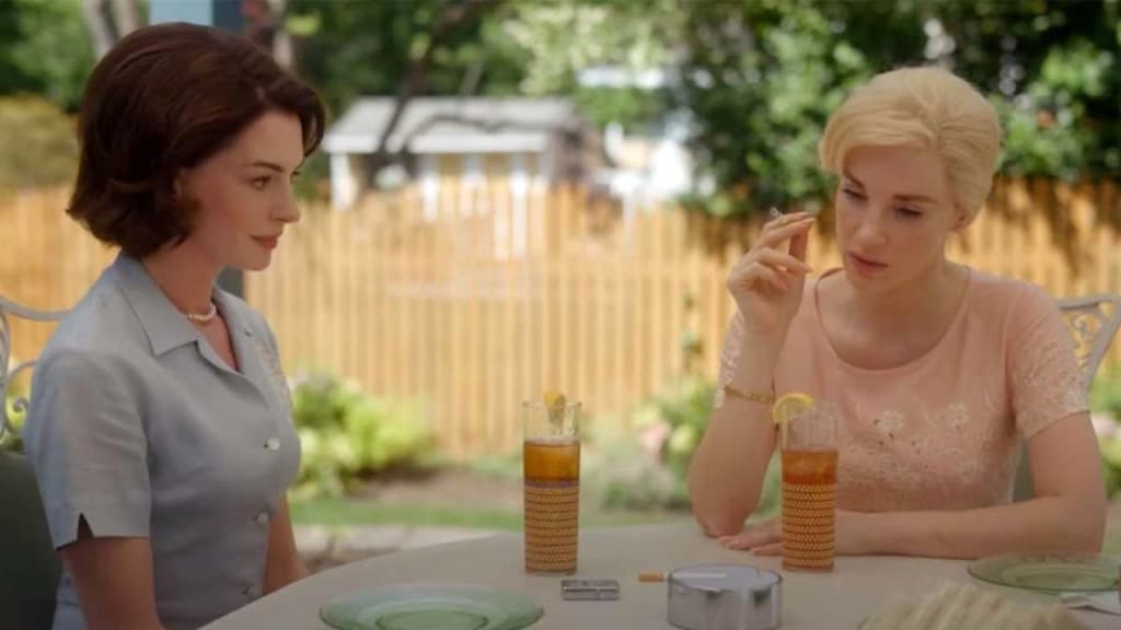 Two women having a conversation at an outdoor table with iced teas.