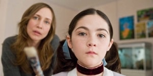 A concerned adult looking at a young girl wearing a neck brace.