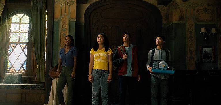 ‘The Spiderwick Chronicles’ Season 1 Review – A Dark Young Adult Series With Grounded Family Drama & Whimsical Adventure Four teenagers stand in awe inside a dimly lit, ornate room, looking towards a light source by the window.