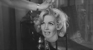 ‘Tormented’ (1960) Blu-Ray Review – Guilt Will Find You In The End A monochrome image of a glamorous woman smiling while a hand adjusts her hair, set in a vintage interior.