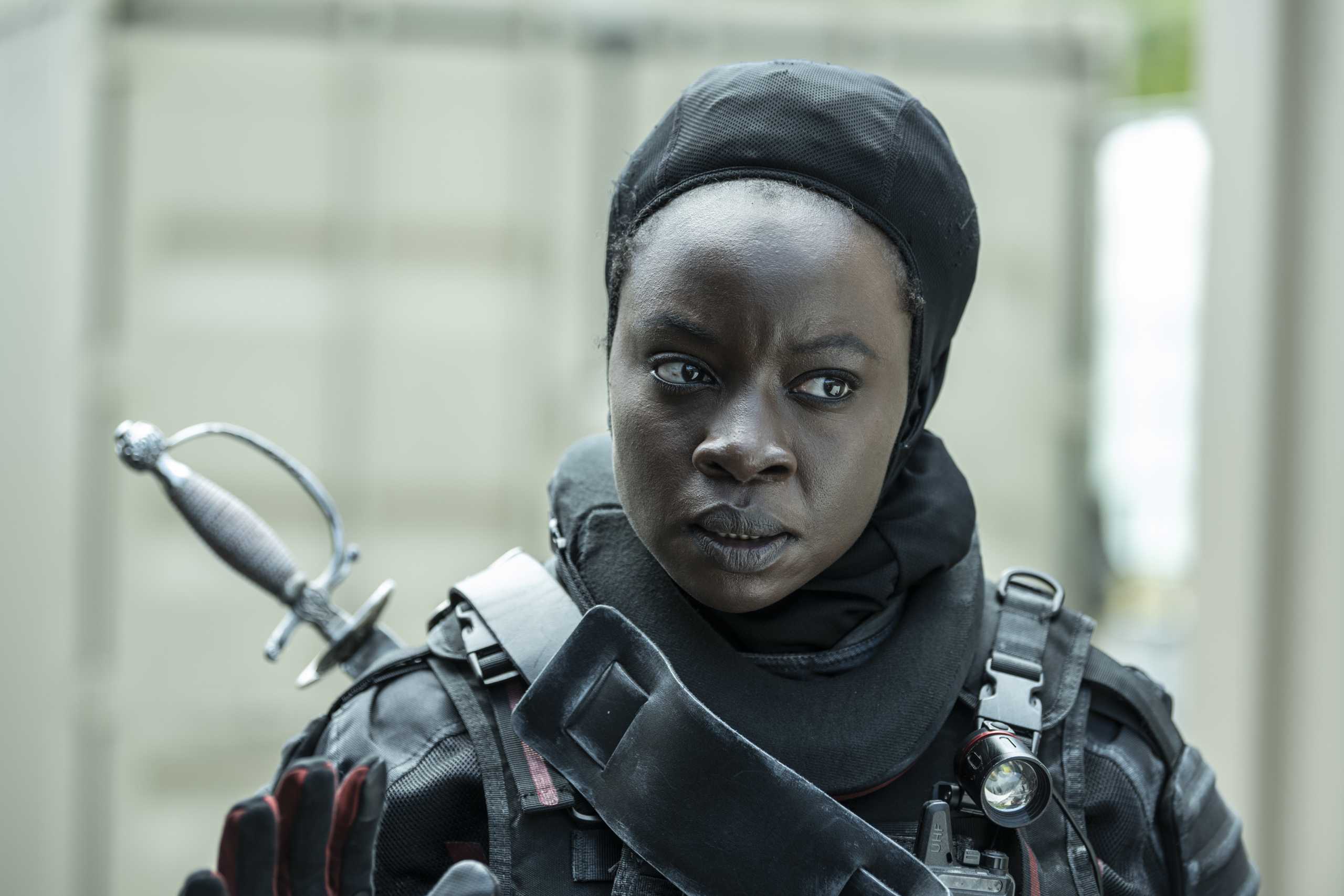 A focused individual in tactical gear with a serious expression.
