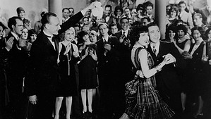 ‘The Boob’ And ‘Why Be Good?’ Silent Double Feature Blu-Ray Review – Throwback Charmers Worth Discovering A black-and-white photo of a man and a woman dancing joyfully in front of an applauding crowd at a formal event.