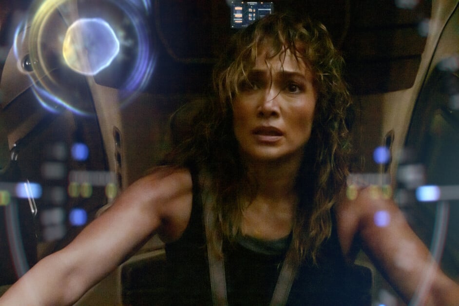A person with wet hair looks distressed while sitting in a futuristic cockpit, surrounded by holographic displays.
