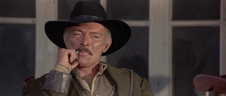 ‘Death Rides A Horse’ (Special Edition) Blu-Ray Review – Lee Van Cleef Anchors Sturdy Spaghetti Western A middle-aged man in a cowboy hat and jacket pensively touches his mustache, sitting by a window.