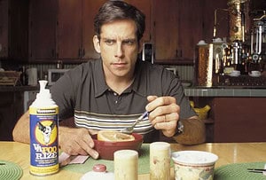 ‘Envy’ Blu-Ray Review – Ben Stiller & Jack Black’s Darkly Comedic Look At The Path Not Taken Man sitting at a kitchen table, looking at the camera while eating cereal, with a can of "yafoo raze" insecticide on the table.