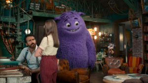 A man and a girl are talking in a cozy, cluttered room, joined by a large, friendly-looking purple creature and a small animal character in the background.